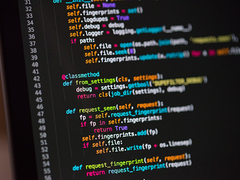Syntax-highlighted source code on a monitor, representing HTML, CSS and JS assets
