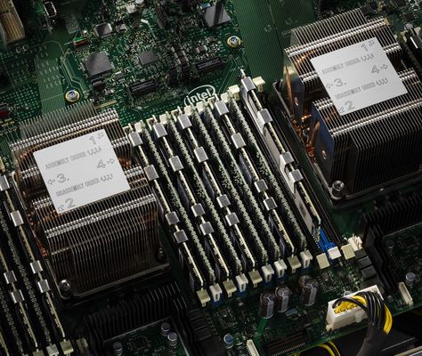 Close-up of a server motherboard with two CPU heatsinks and a full bank of memory modules